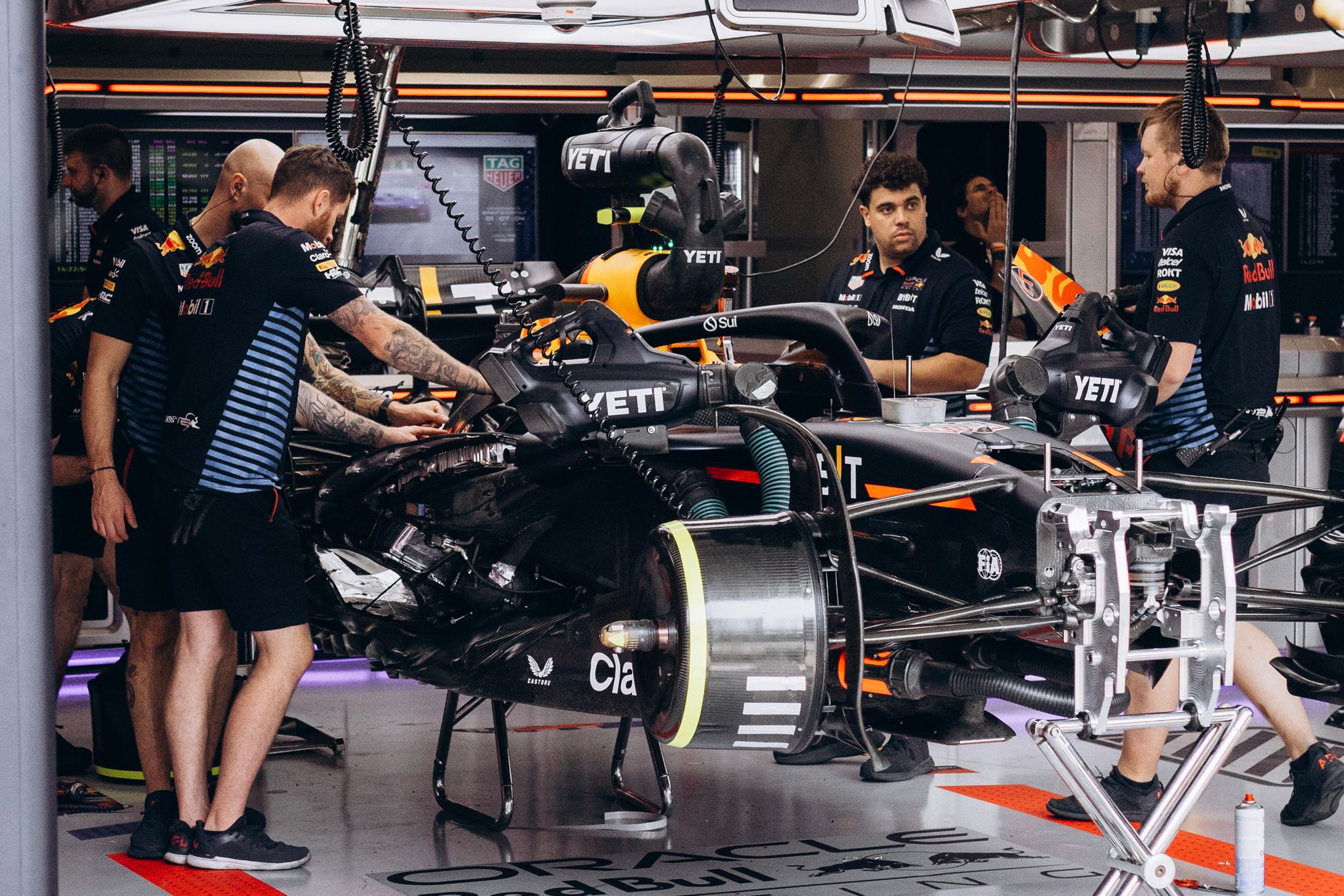 Formula 1 garage engineers working on a car during a race weekend