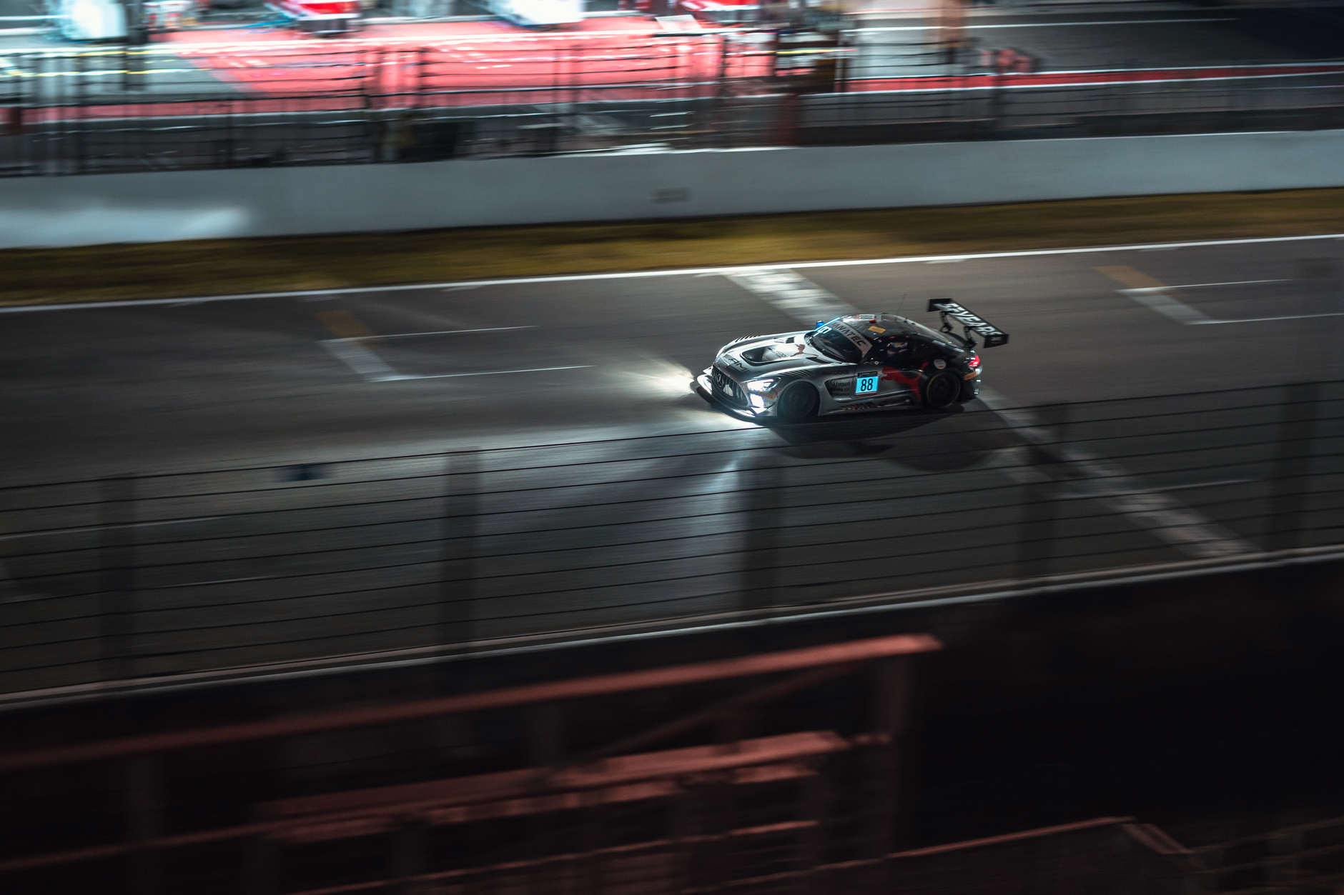 Hypercar prototypes racing at dusk on the Circuit de la Sarthe