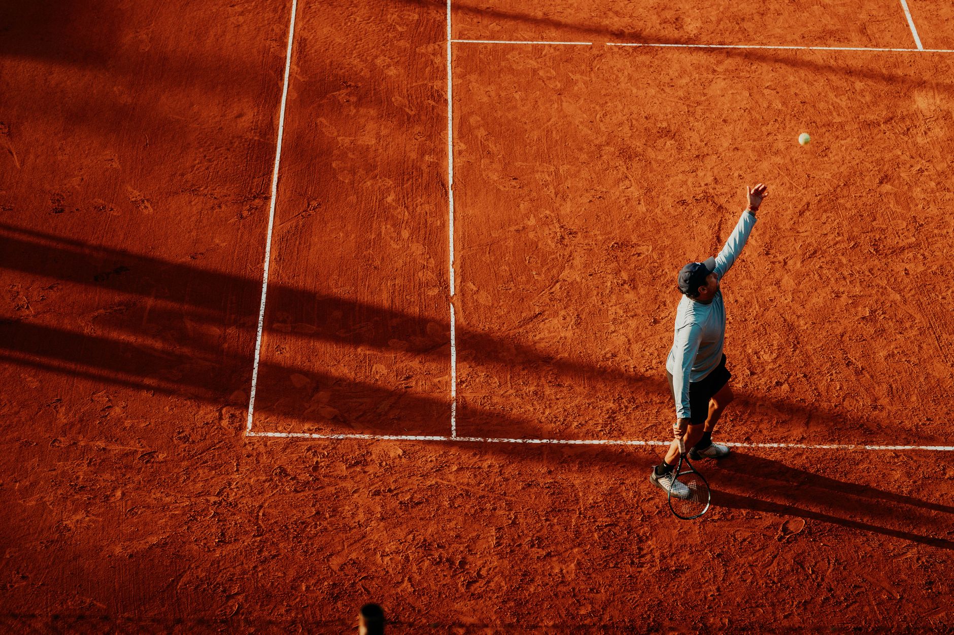 tennis player hitting forehand on red clay court